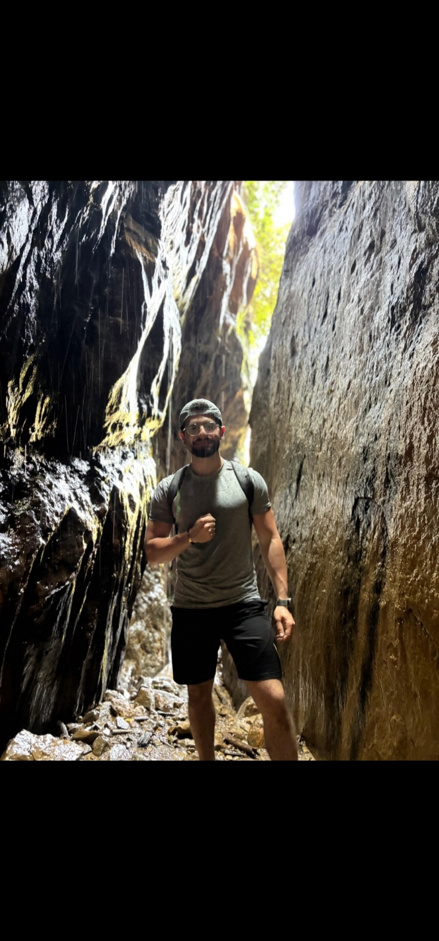 Joseph hiking through a narrow rocky canyon